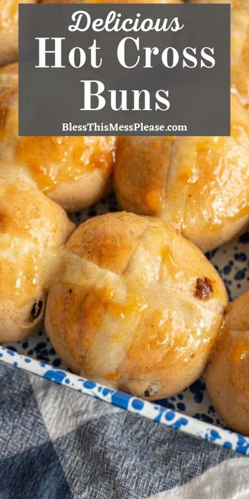 up close picture of hot cross buns in a baking dish with the words "delicious hot cross buns" written at the top