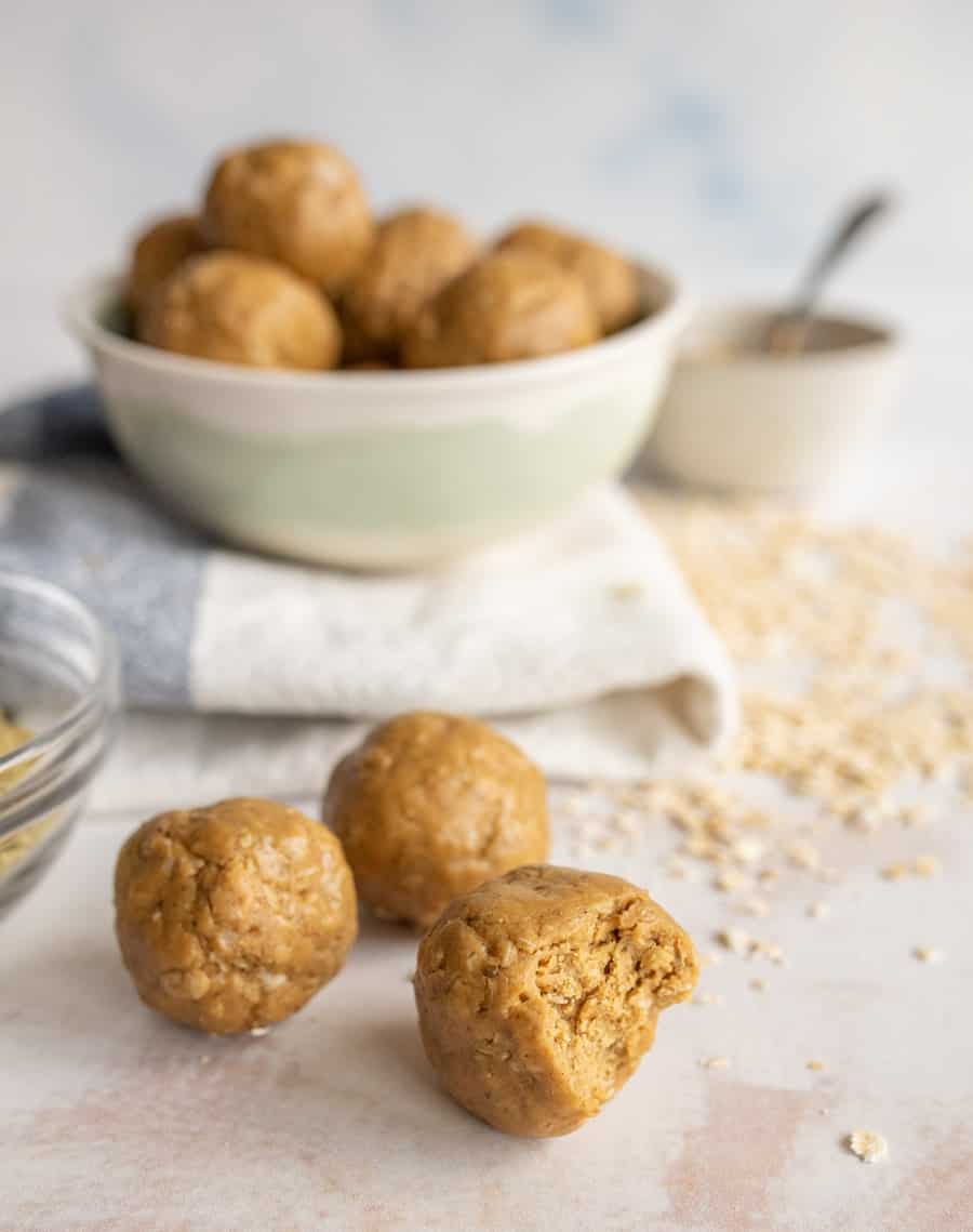 picture of peanut butter protein balls with a bowl of them in the background