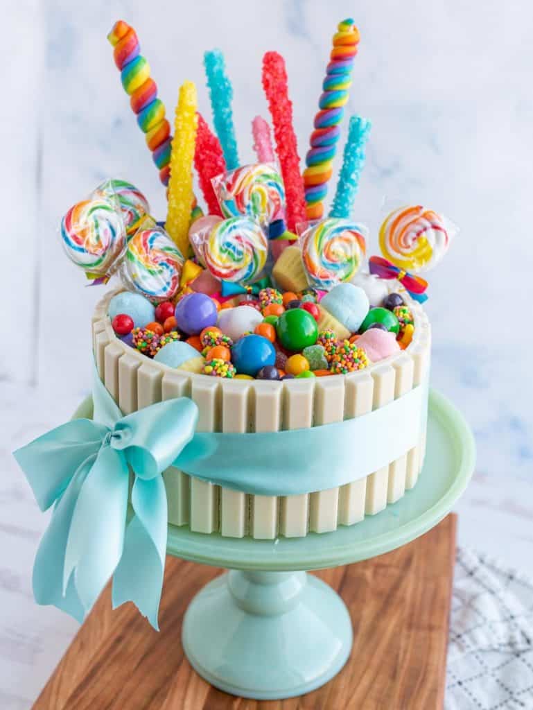picture of a candy cake on a cake plate, with a bow wrapped around it