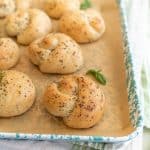 close up picture of garlic knots on a baking sheet