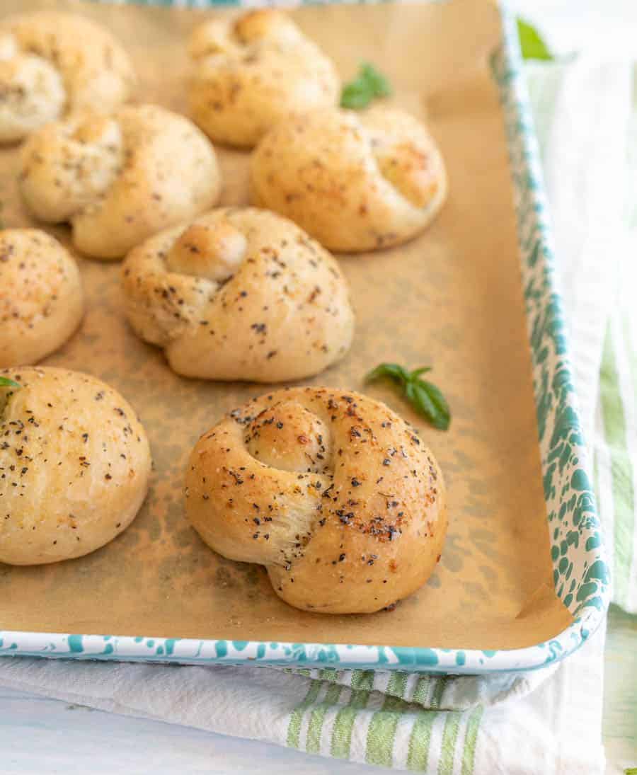 close up picture of garlic knots on a baking sheet