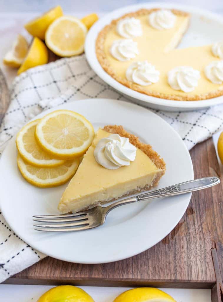 a plate of lemon pie next to the pie