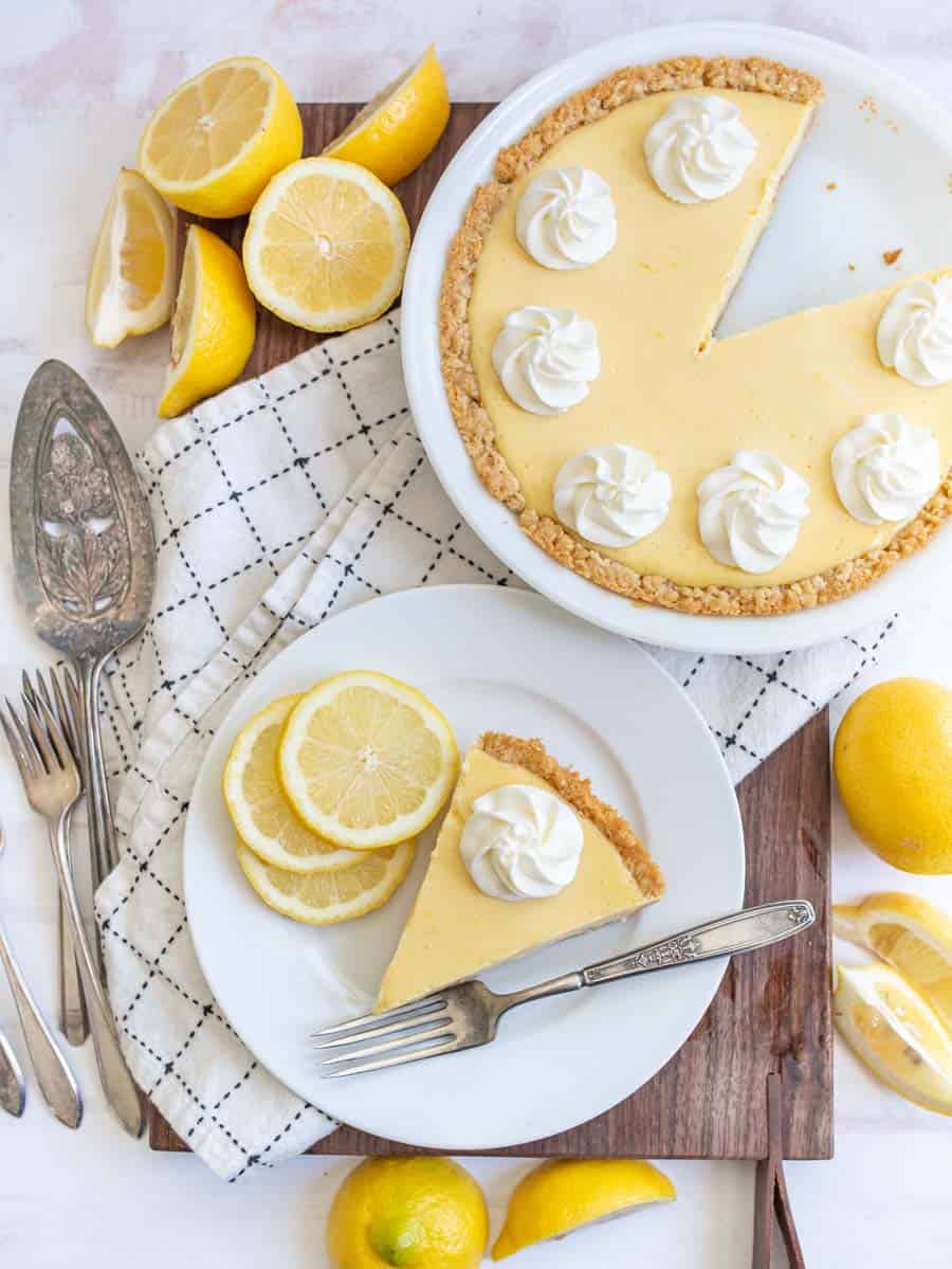 top view of a plate of lemon pie next to the pie