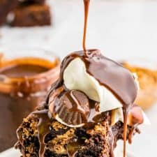 Picture of hot fudge being poured over a peanut butter brownie sundae