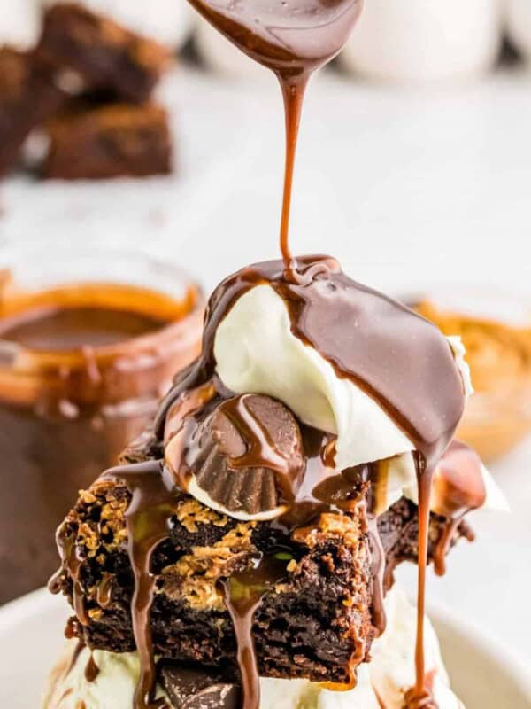 Picture of hot fudge being poured over a peanut butter brownie sundae