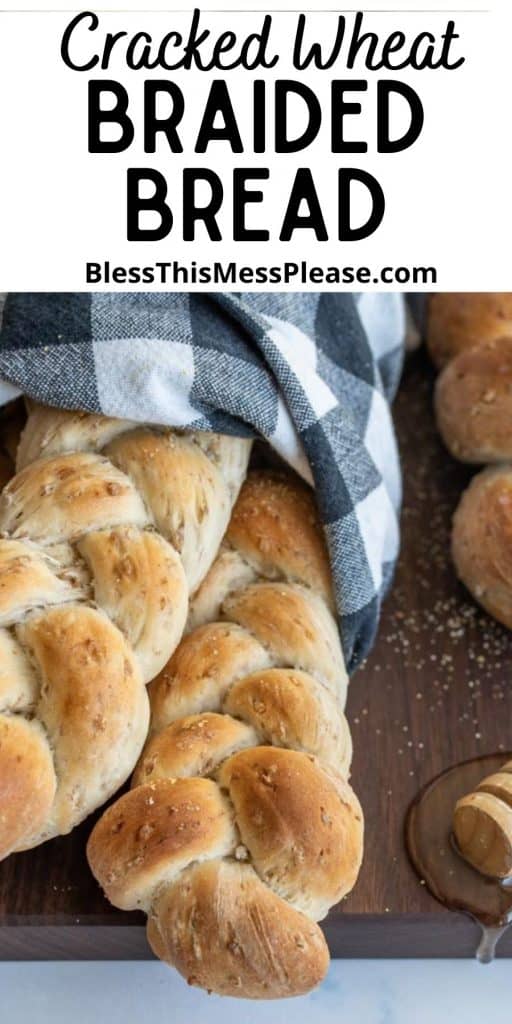 Picture of two loaves of braided bread wrapped in a towel with the words "cracked wheat braided bread" written at the top