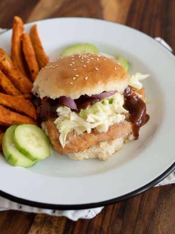 close up picture of pork chop sandwich on a plate with a side of sweet potato fries