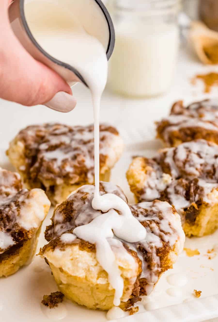 glaze being poured over monkey bread muffins