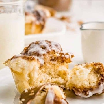 monkey bread muffin cut in half on plate with cup of milk in background