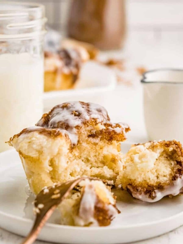 monkey bread muffin cut in half on plate with cup of milk in background