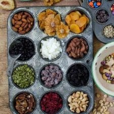 top view of muffin tins filled with different ingredients for trail mix