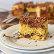 close up picture of a piece of coffee cake on a plate with a fork next to it