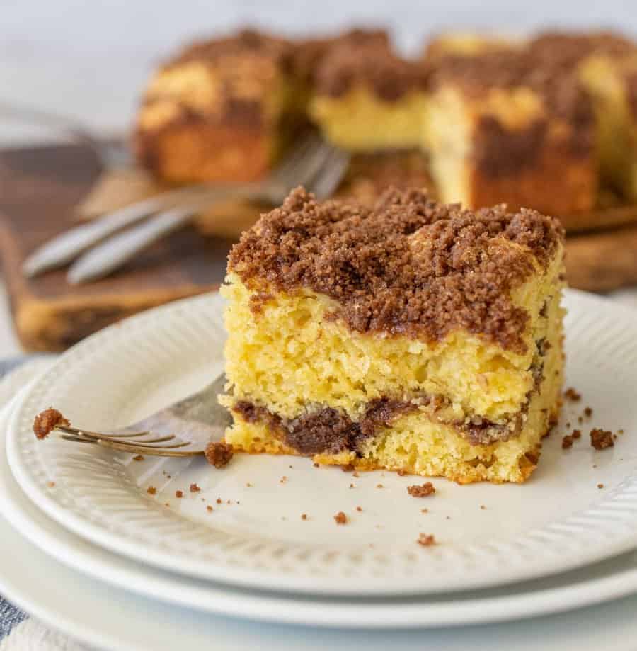 a slice of coffee cake and a fork on a white plate