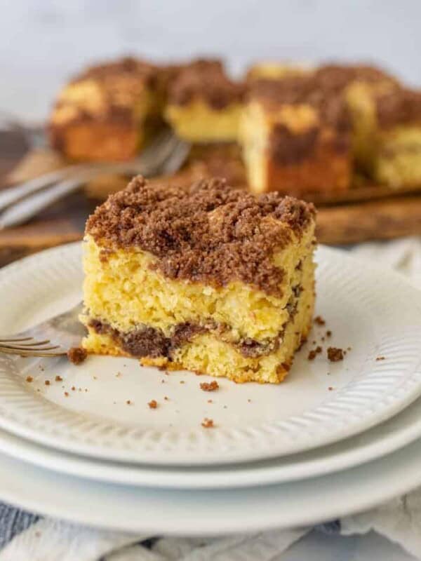 close up picture of a piece of coffee cake on a plate with a fork next to it