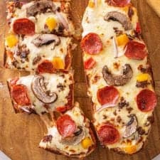 top view of two French bread pizzas, one of them being cut