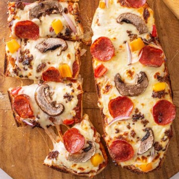 top view of two French bread pizzas, one of them being cut