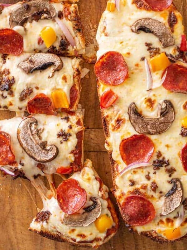 top view of two French bread pizzas, one of them being cut