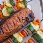 close up picture of a grilled pork loin with grilled vegetable kabobs next to it