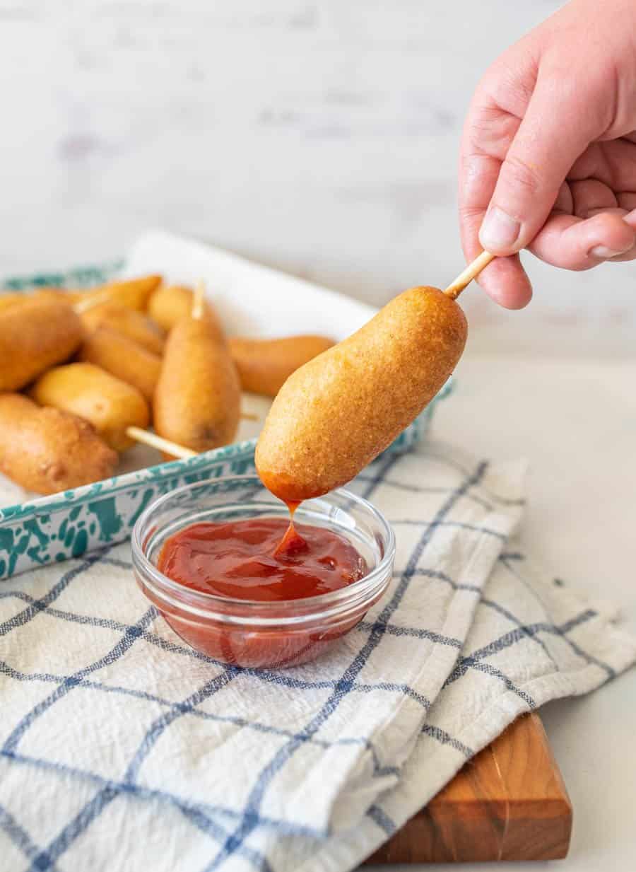 corndog being dipped into ketchup