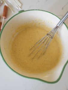top top view of bowl filled with batter and a whisk in it.