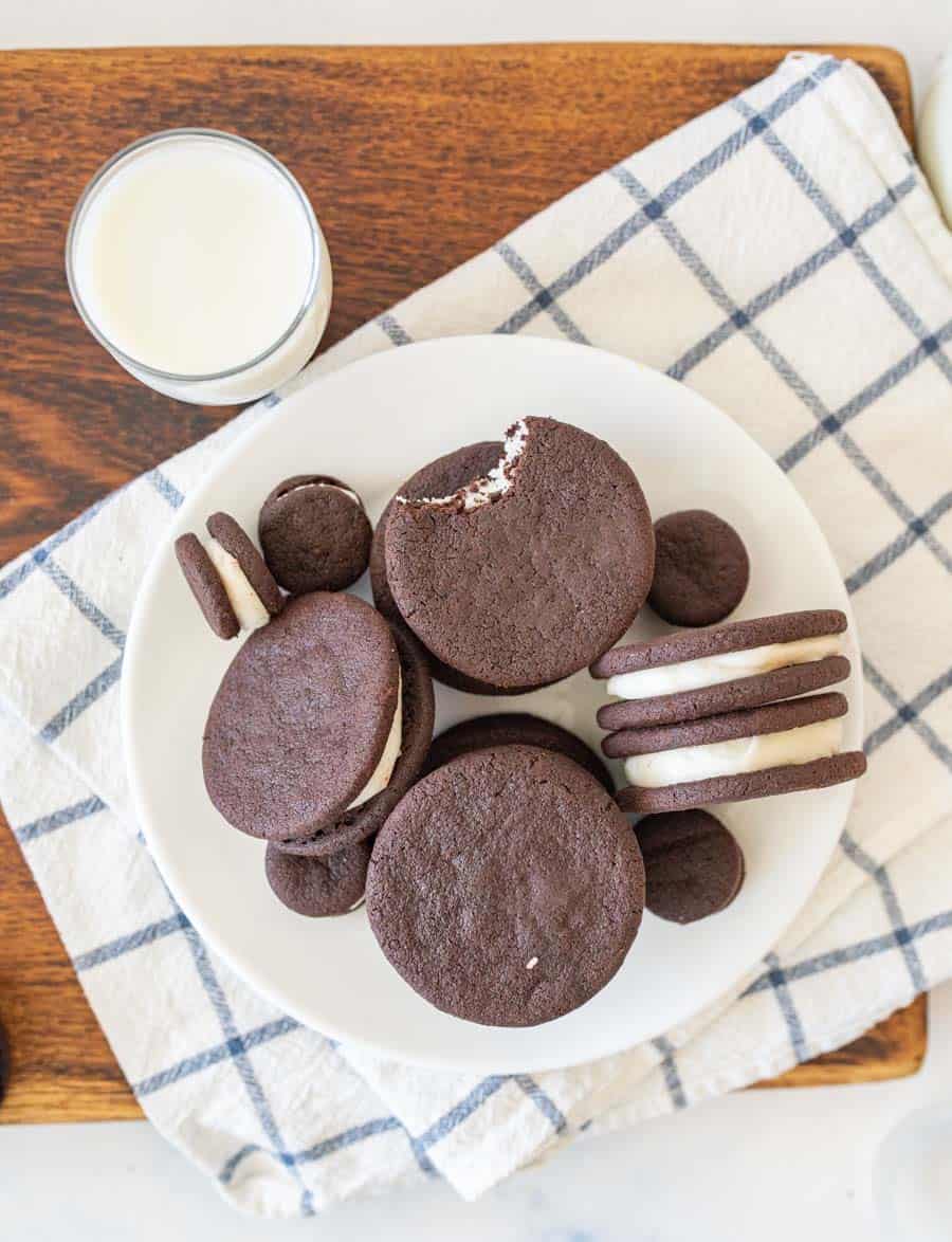 top view of a plate of homemade oreos with a glass of milk next to it