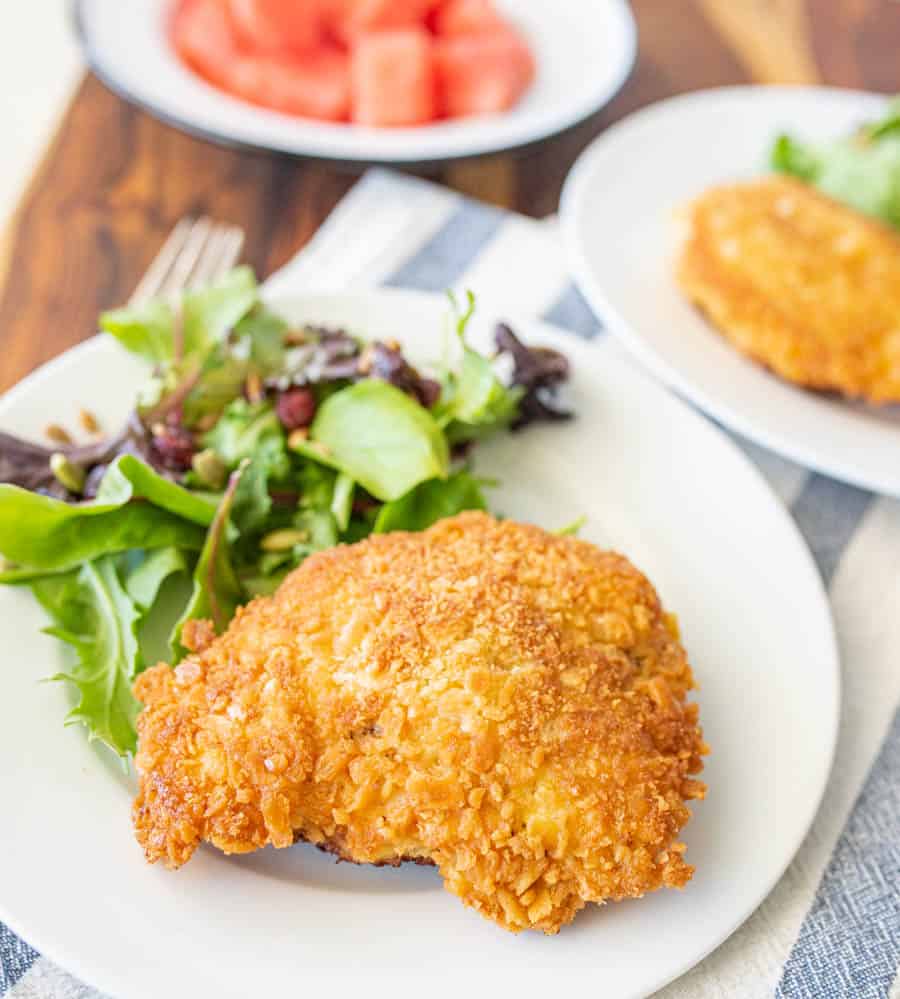 parmesan crusted chicken and salad on a white plate