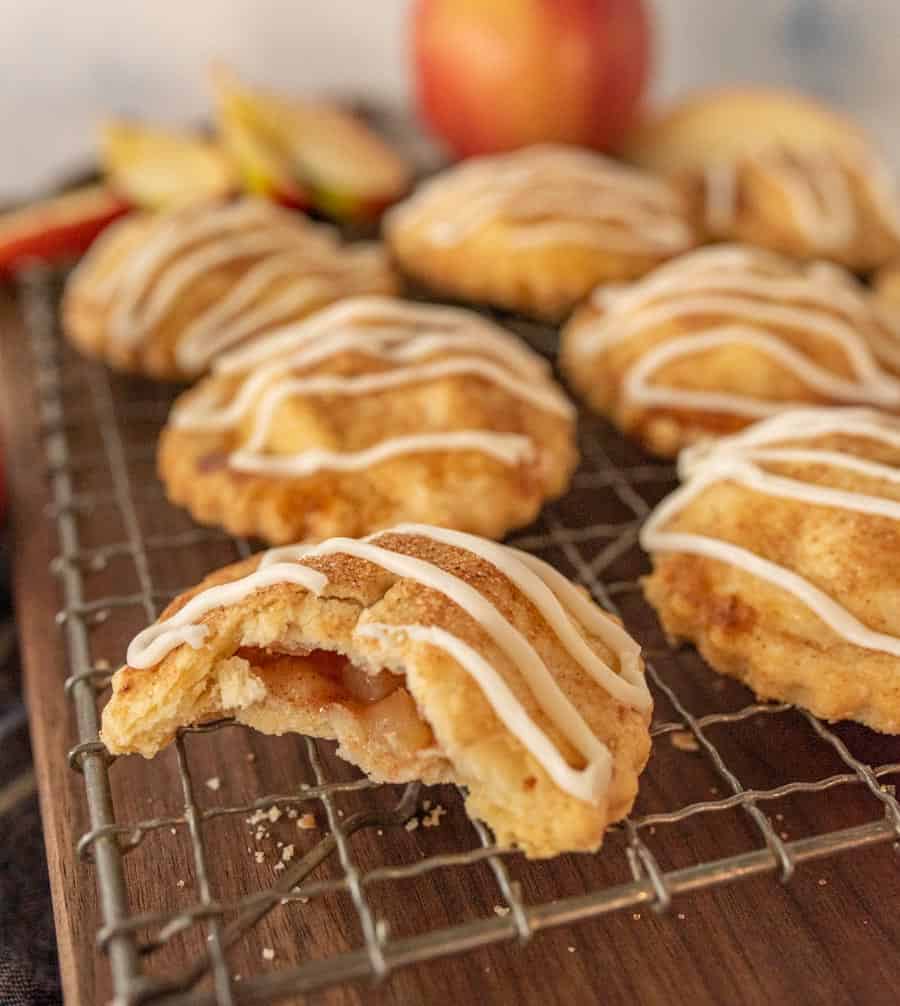 close up of an apple hand pie with a bite taken out of it on a cooling rack