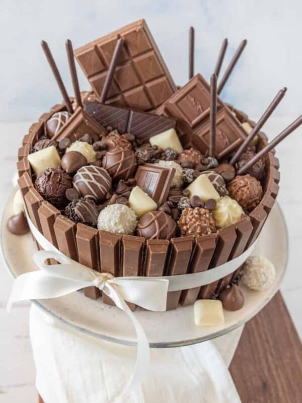 top view of chocolate candy cake tied with a ribbon on a cake stand