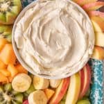 close up of a bowl of fruit dip and fruit on a tray