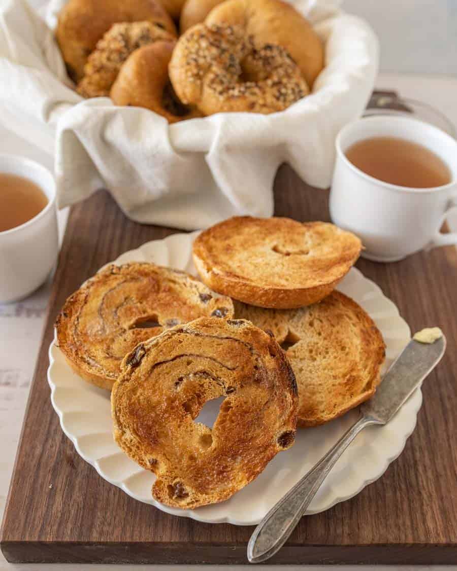 bagels sliced and toasted on a plate with a knife