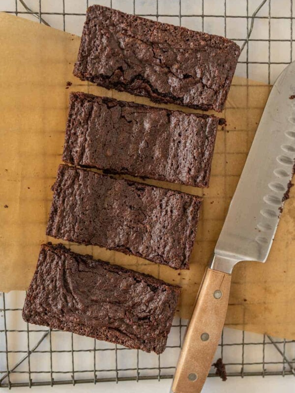 top view of brownies cut into bars next to a knife on a cooling rack