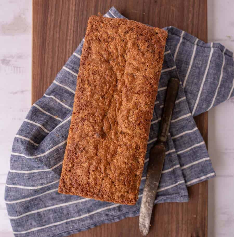 top view of a loaf of zucchini bread next to a butter knife