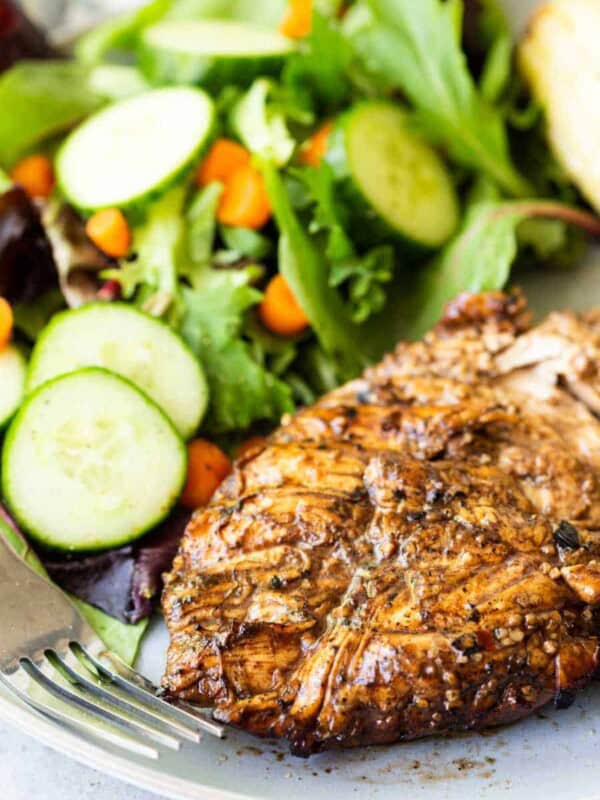 close up of balsamic chicken and a salad on a plate