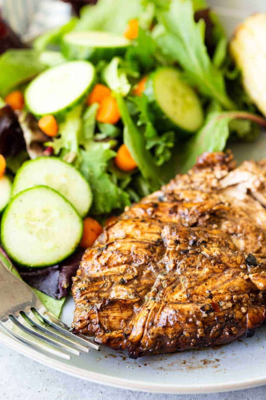 close up of balsamic chicken and a salad on a plate