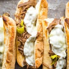 top view of a pan of Italian beef sandwiches with melted cheese on top