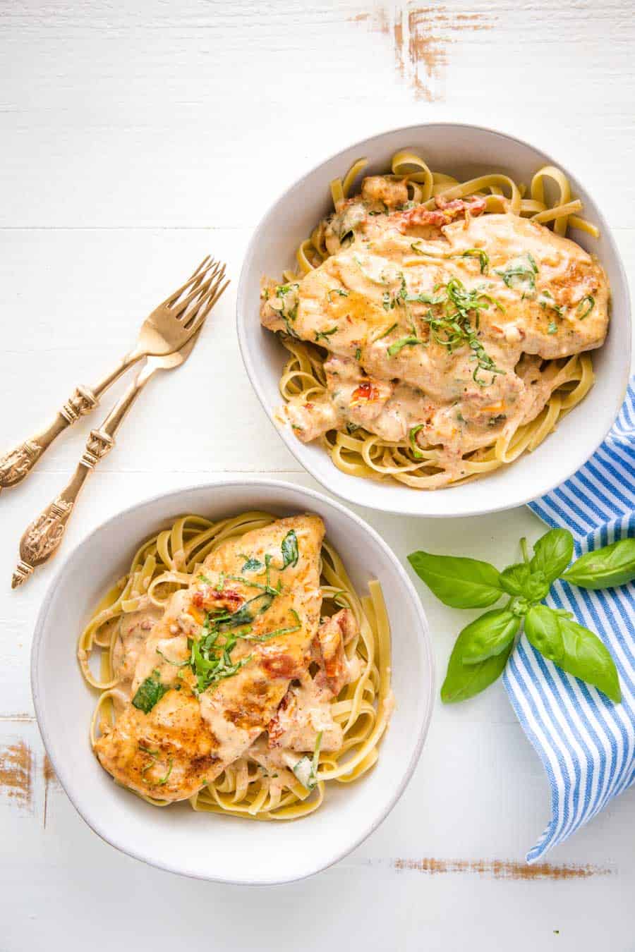 top view of bowls of Tuscan chicken over pasta