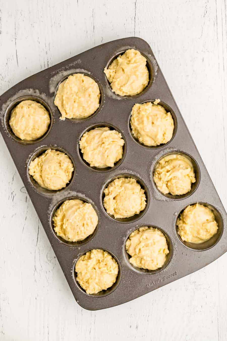 homemade cornbread muffin batter in tins ready to bake.