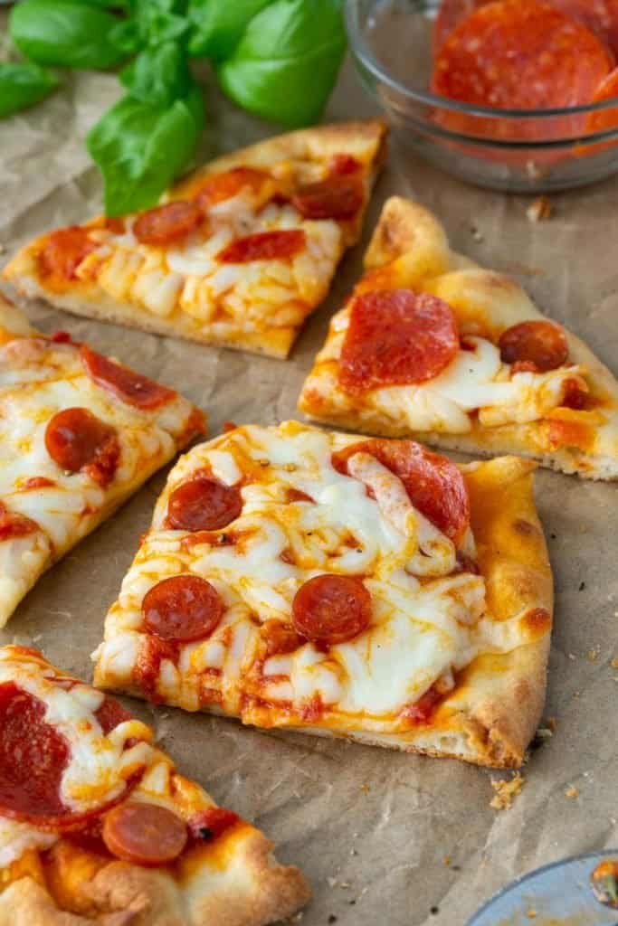 Sliced pepperoni and cheese pizza on parchment paper
