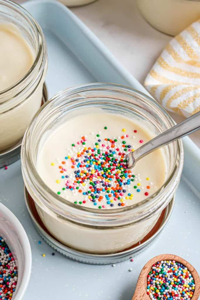 jar of vanilla pudding with rainbow sprinkles on them