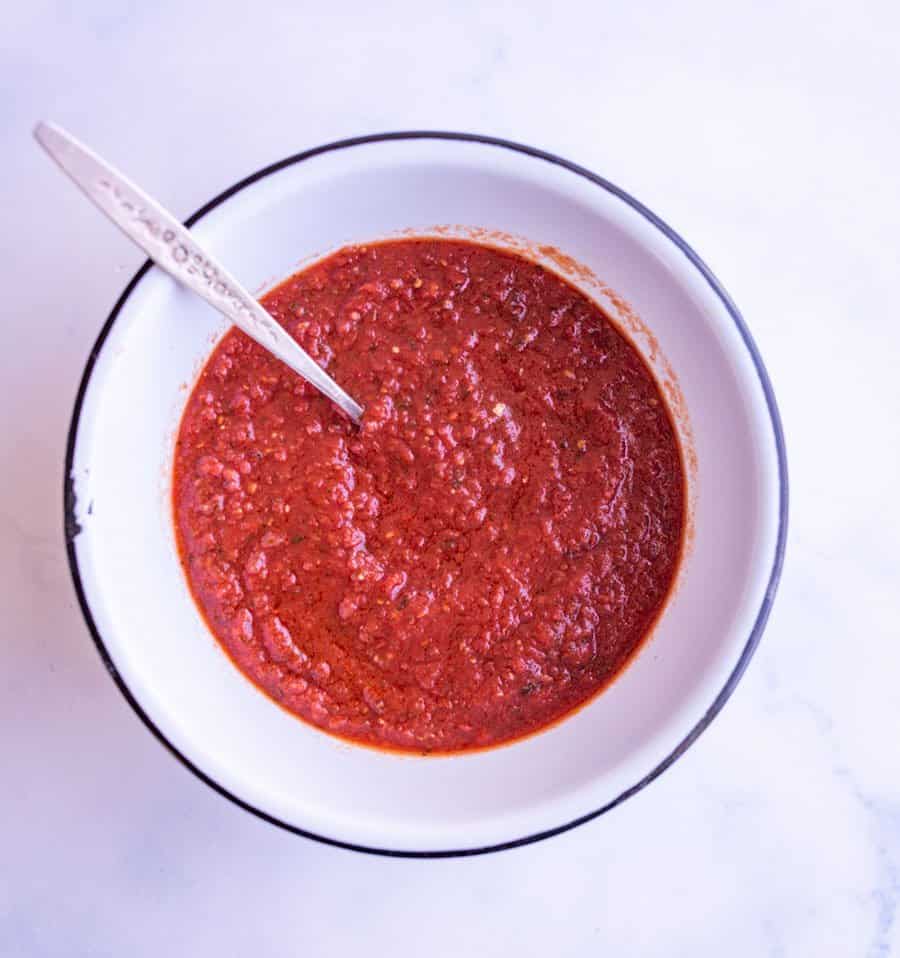 Pizza sauce in a white dish.