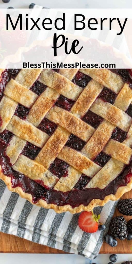 pinterest pin with text that reads "mixed berry pie" - top view of a whole berry pie that has a baked golden lettuce top and deep purple and red showing through