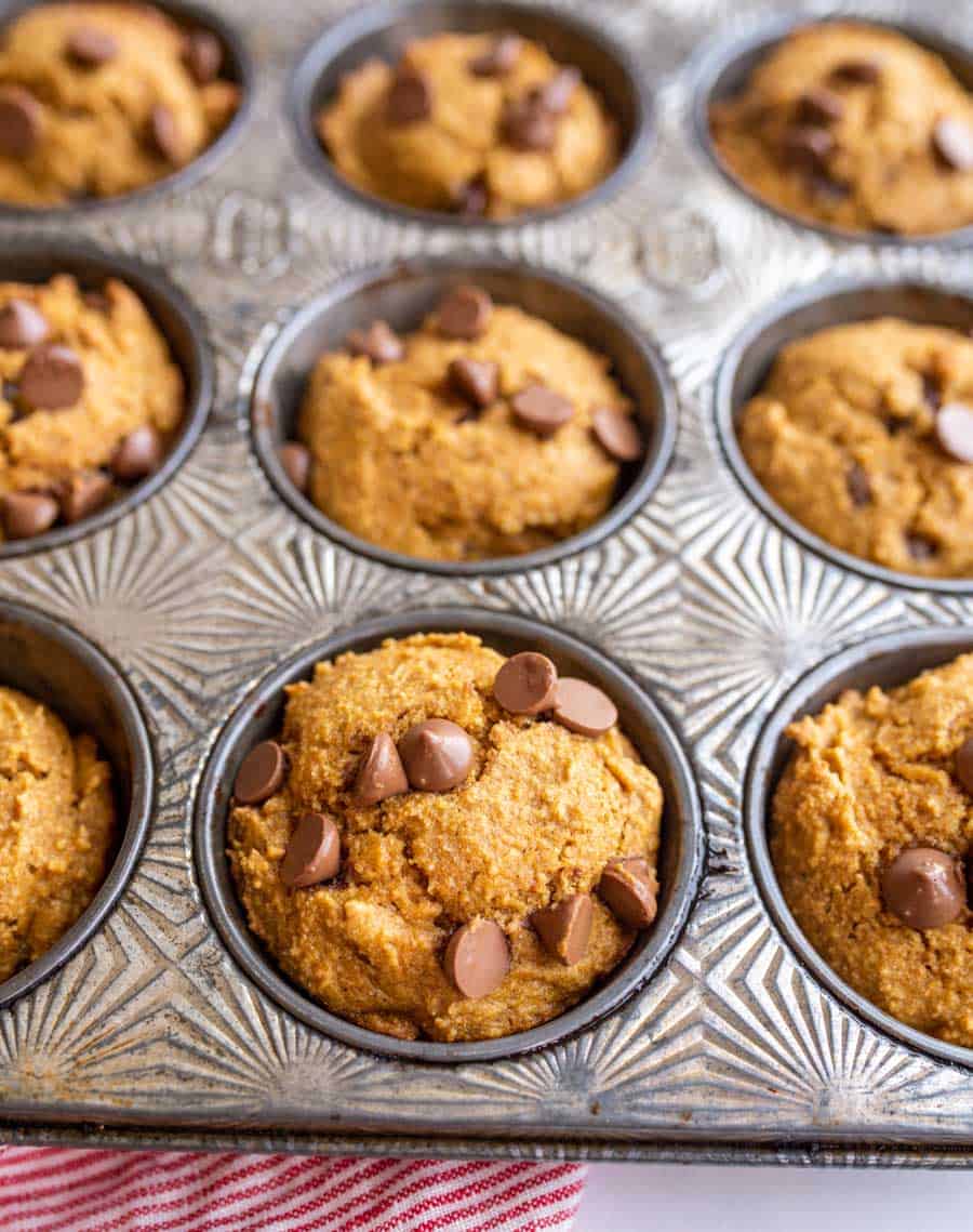 A close up of a muffin tin with baked whole wheat pumpkin muffins.