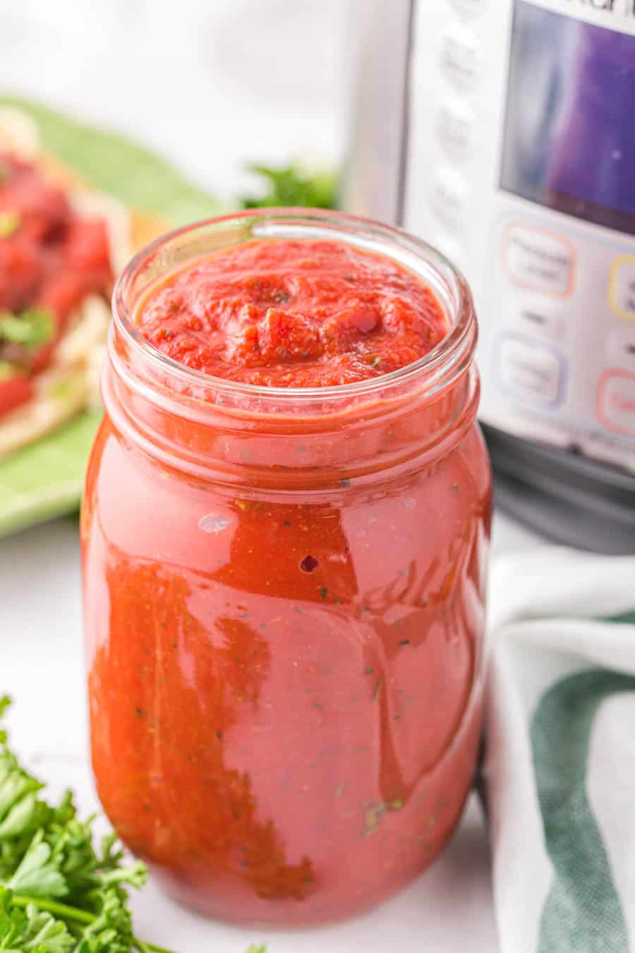 Close up of a glass jar filled with Instant Pot spaghetti sauce.