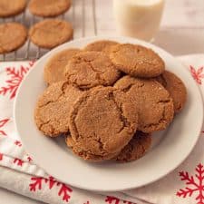 scene with ginger snap cookies on a rack and also piled on a plate with milk and festive napkins