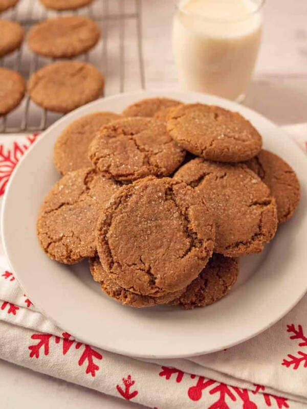 scene with ginger snap cookies on a rack and also piled on a plate with milk and festive napkins