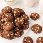 chocolate cookies with white chips piled on a plate.