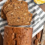 close up top view of the traditional loaf of nut bread sliced and showing all the hues of brown in the center facing up and we see the crunchy cinnamon crust