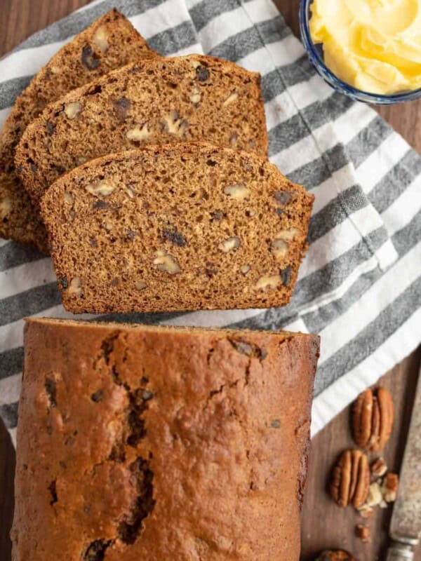 close up top view of the traditional loaf of nut bread sliced and showing all the hues of brown in the center facing up and we see the crunchy cinnamon crust