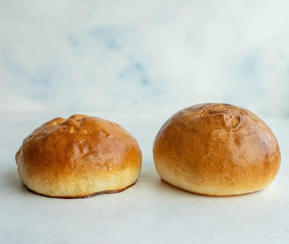 artistic photo of two golden brown rolls against a white background.