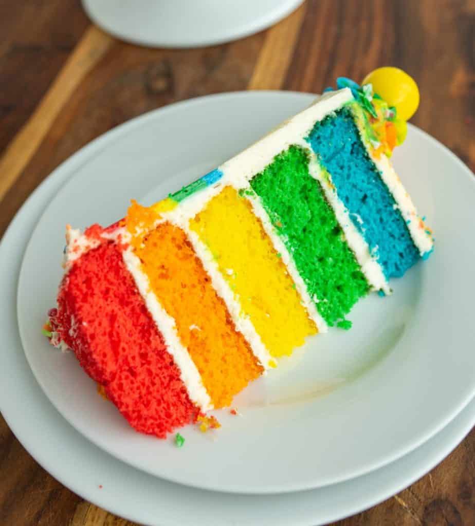 slice of rainbow layer cake colors start red orange yellow green yellow